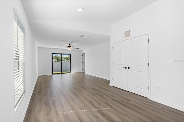 unfurnished room with visible vents, ceiling fan, wood finished floors, and baseboards