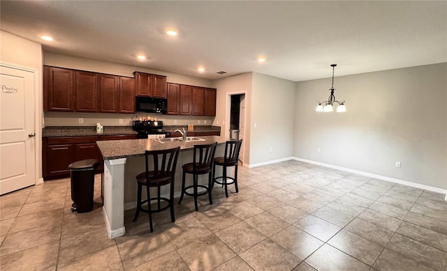 12717 Lemon Pepper Dr, Riverview, FL 33578 - kitchen featuring black appliances, a chandelier, dark countertops, a kitchen breakfast bar, and a kitchen island with sink