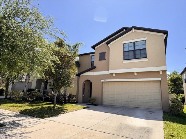 12717 Lemon Pepper Dr, Riverview, FL 33578 - view of front facade with stucco siding, an attached garage, and driveway