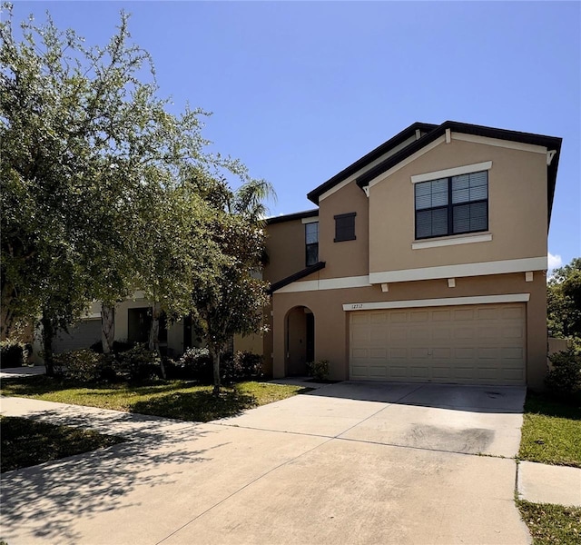 12717 Lemon Pepper Dr, Riverview, FL 33578 - view of front of house with stucco siding, an attached garage, and concrete driveway