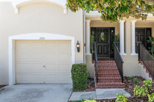 1105 Venetian Harbor Dr NE, Saint Petersburg, FL 33702 - property entrance featuring stucco siding, a garage, and concrete driveway