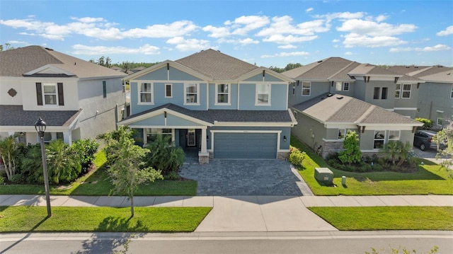 craftsman inspired home with a residential view, decorative driveway, an attached garage, and a front yard
