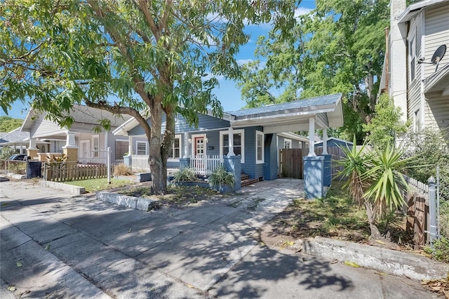 2920 N 11th St, Tampa, FL 33605 - single story home with concrete driveway, an attached carport, metal roof, fence, and covered porch