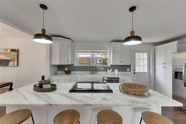 2920 N 11th St, Tampa, FL 33605 - kitchen featuring white cabinetry, a kitchen bar, decorative backsplash, stainless steel appliances, and a sink