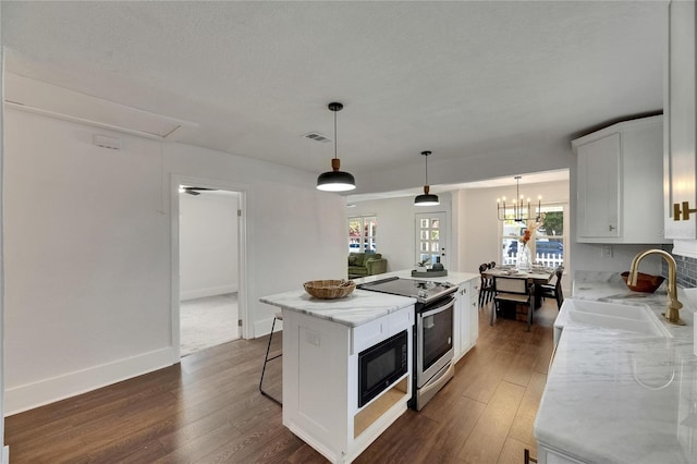 2920 N 11th St, Tampa, FL 33605 - kitchen with black microwave, a center island, stainless steel range with electric stovetop, visible vents, and a sink