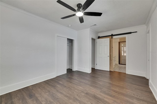 2920 N 11th St, Tampa, FL 33605 - unfurnished bedroom featuring crown molding, visible vents, a barn door, and wood finished floors