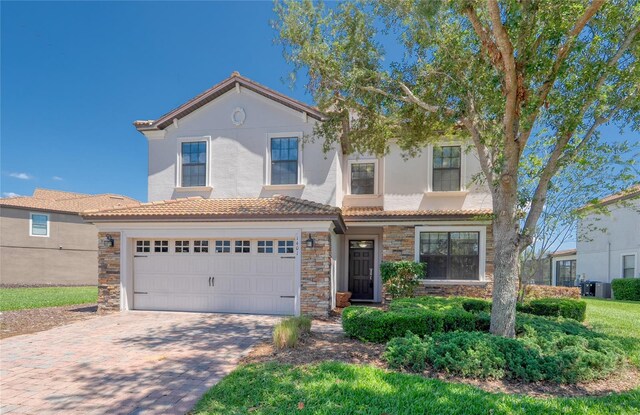 1401 Wexford Way, Davenport, FL 33896 - view of front facade with driveway, stone siding, a tiled roof, stucco siding, and a garage