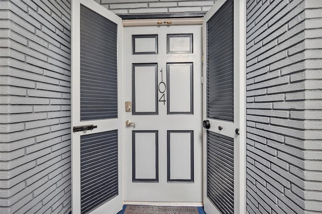view of exterior entry featuring brick siding