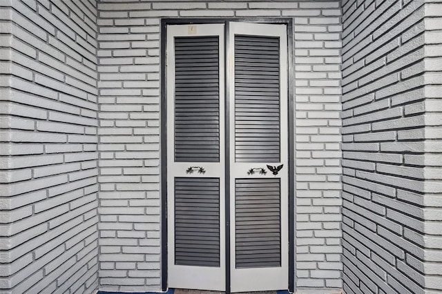 doorway to property with brick siding