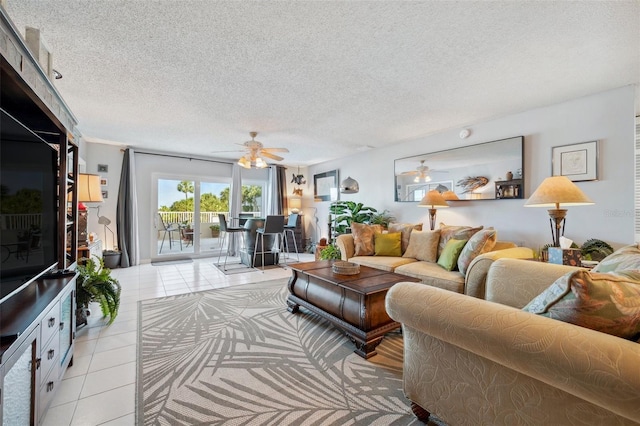 living room with a textured ceiling, ceiling fan, and light tile patterned floors