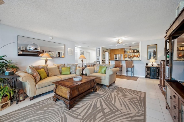 living area with a textured ceiling and light tile patterned flooring