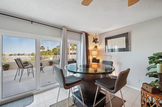 dining area with a textured ceiling, light tile patterned floors, and a ceiling fan