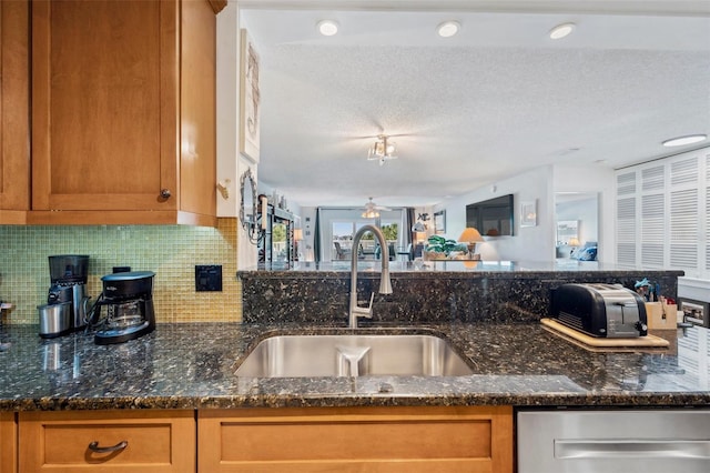 kitchen with a sink, brown cabinetry, tasteful backsplash, and a ceiling fan