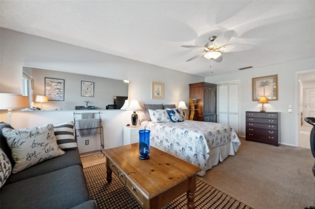 bedroom with a closet, light colored carpet, ceiling fan, and visible vents