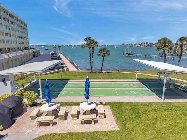 view of home's community with a yard, shuffleboard, and a water view