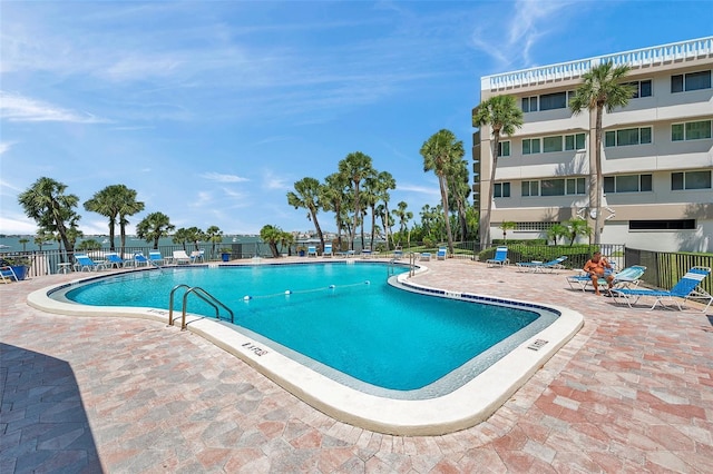 community pool featuring a patio and fence