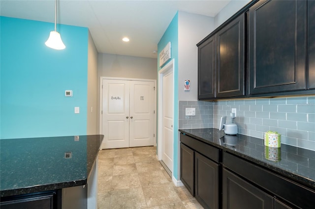 kitchen with baseboards, recessed lighting, dark stone counters, decorative backsplash, and pendant lighting