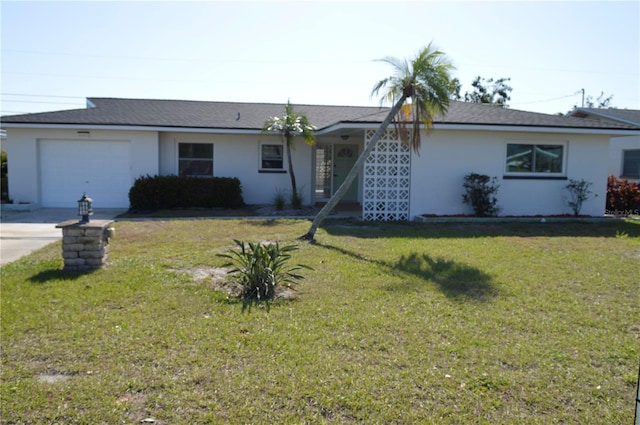 ranch-style home featuring a front yard, an attached garage, concrete driveway, and stucco siding