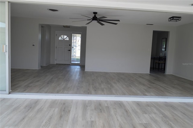 foyer entrance featuring visible vents, wood finished floors, and ceiling fan