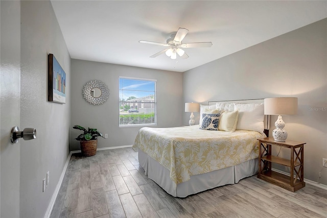 bedroom featuring light wood-type flooring, baseboards, and ceiling fan