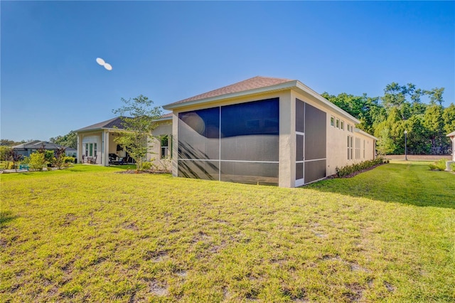 back of house featuring a yard and a sunroom