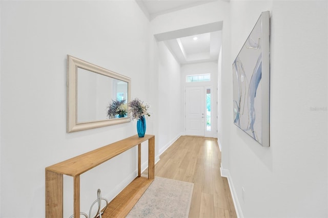 foyer featuring recessed lighting, light wood finished floors, baseboards, and a raised ceiling