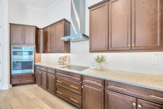 kitchen featuring wall chimney exhaust hood, double oven, ornamental molding, light stone counters, and black electric cooktop