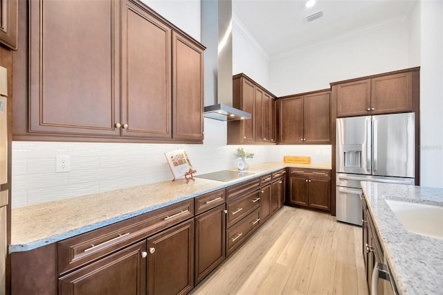 kitchen with crown molding, stainless steel fridge with ice dispenser, wall chimney exhaust hood, light wood-style flooring, and black electric cooktop