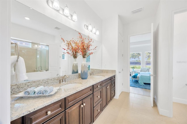 ensuite bathroom featuring double vanity, visible vents, baseboards, and a sink