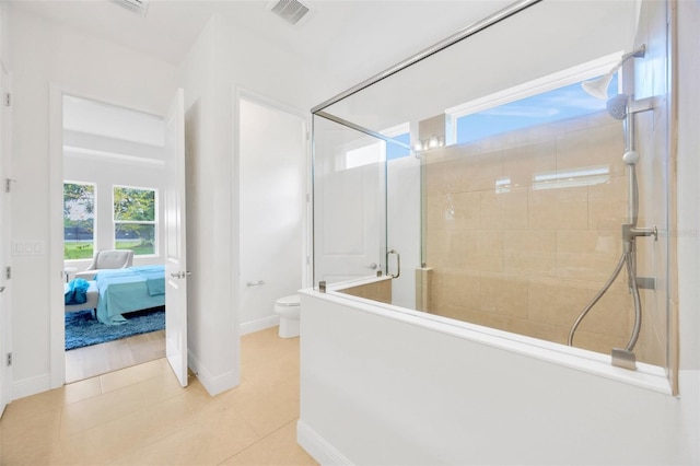 ensuite bathroom featuring baseboards, a stall shower, tile patterned floors, toilet, and visible vents