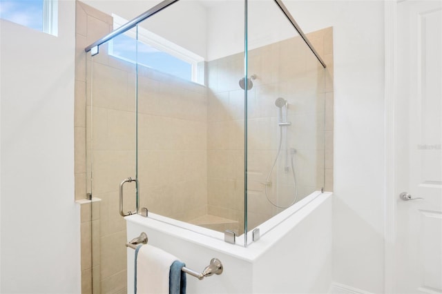 full bathroom with a tile shower and plenty of natural light