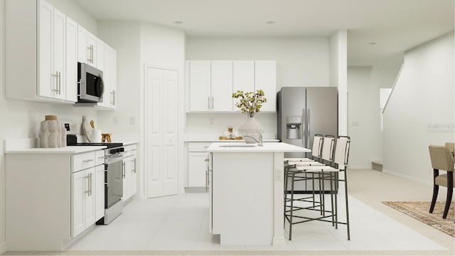 kitchen featuring white cabinets, a kitchen island with sink, light countertops, stainless steel appliances, and a breakfast bar area