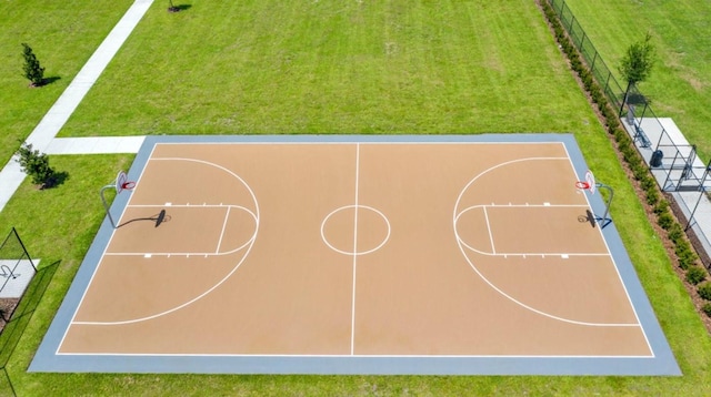 view of sport court with community basketball court, fence, and a yard