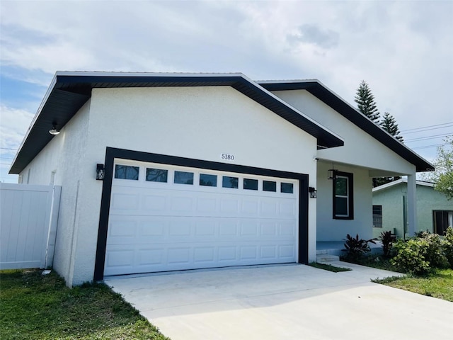ranch-style house featuring stucco siding, fence, driveway, and an attached garage