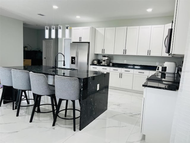 kitchen with marble finish floor, a sink, stainless steel refrigerator with ice dispenser, and black microwave