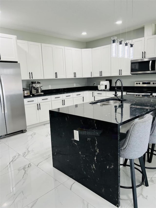 kitchen featuring a breakfast bar, marble finish floor, a sink, and stainless steel appliances