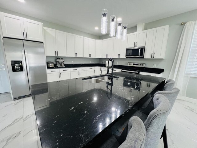 kitchen featuring decorative light fixtures, appliances with stainless steel finishes, marble finish floor, a sink, and white cabinetry