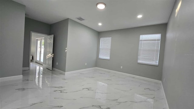 unfurnished room featuring baseboards, visible vents, marble finish floor, and recessed lighting