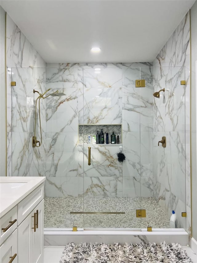 bathroom with a marble finish shower, marble finish floor, and vanity