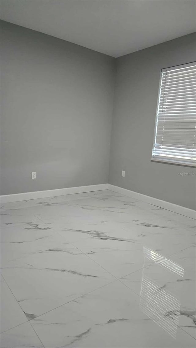 empty room with marble finish floor and baseboards