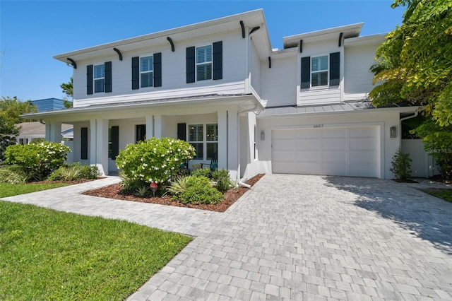 3607 W Roland St, Tampa, FL 33609 - view of front of house featuring a standing seam roof, metal roof, decorative driveway, covered porch, and an attached garage