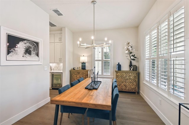 3607 W Roland St, Tampa, FL 33609 - dining room with wood finished floors, a chandelier, baseboards, visible vents, and wine cooler