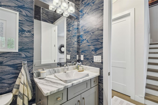 3607 W Roland St, Tampa, FL 33609 - bathroom with wallpapered walls, wood finished floors, and vanity
