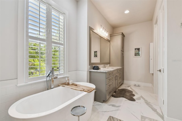 3607 W Roland St, Tampa, FL 33609 - bathroom featuring baseboards, recessed lighting, a freestanding tub, vanity, and marble finish floor