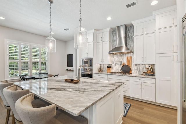 3607 W Roland St, Tampa, FL 33609 - kitchen with a sink, visible vents, stainless steel appliances, recessed lighting, and wall chimney exhaust hood