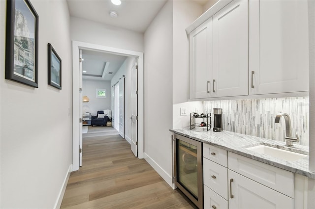3607 W Roland St, Tampa, FL 33609 - bar with decorative backsplash, a sink, beverage cooler, baseboards, and light wood finished floors