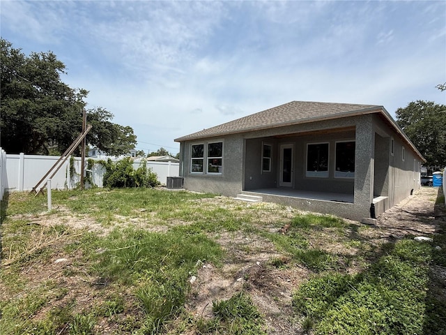 1828 27th Ave N, Saint Petersburg, FL 33713 - rear view of house with stucco siding, a patio area, and central AC unit