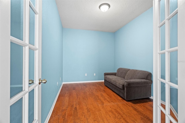19232 Barred Owl Ct, Land O Lakes, FL 34638 - living area featuring french doors, a textured ceiling, and wood finished floors