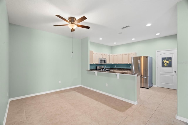 19232 Barred Owl Ct, Land O Lakes, FL 34638 - kitchen featuring appliances with stainless steel finishes, dark countertops, a peninsula, a kitchen breakfast bar, and ceiling fan