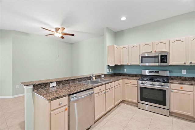 19232 Barred Owl Ct, Land O Lakes, FL 34638 - kitchen with stainless steel appliances, a peninsula, light tile patterned floors, a ceiling fan, and dark stone countertops